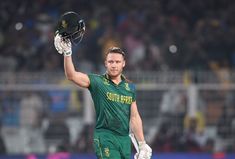 a man in green uniform holding a black helmet