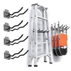 the ladder is holding several pairs of orange and black items