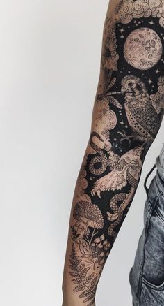 a man with an owl tattoo on his arm and leg is standing in front of a white wall