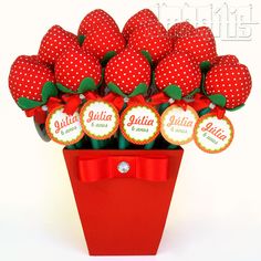 a red vase filled with lots of strawberries