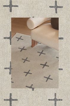 a rug with crosses on it in front of a chair and floor mat that has been placed on the floor