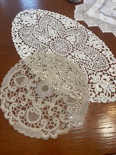 three white doily sitting on top of a wooden table