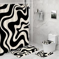 a black and white shower curtain next to a toilet in a bathroom with marble walls