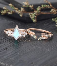 three different types of rings on top of a wooden table next to some flowers and leaves