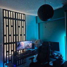 a computer desk with a monitor and keyboard on it in a room that has blue lighting