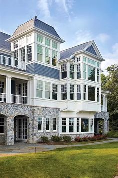 a large white house with lots of windows on it's sides and balconies