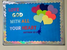 a bulletin board with balloons and the words love god with all your heart written on it