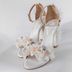 White crystal-embellished flower heeled ankle-strap wedding sandals exude elegance and charm. Perfect for a bridal ensemble, these shoes blend sophistication with a touch of floral whimsy. Color: White Heel Type: Block heel Heel Height: 4'' / 100 mm approx Product measurements were taken using size 8. Please note that measurements may vary by size. Toe: Open toe Crystal embellished design Floral decoration design Adjustable buckled ankle strap design Handcrafted US sizing. Fits true to size. Wedding Block Heels, Bridesmaids Heels, Flower Heels, Wedding Shoes Bride, Flower Sandals, Flower Shoes, Floral Sandals, Floral Heels, Bridal Sandals