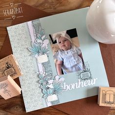 a baby's first birthday card with rubber stamps on it and a white vase next to it