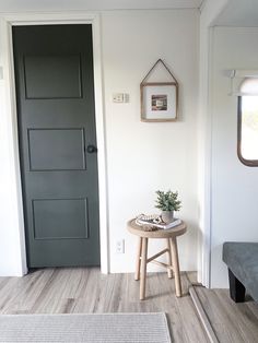 a small table with a plant on it in front of a door