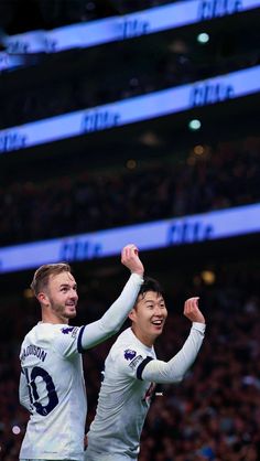 two soccer players are congratulating each other in front of an audience at a sporting event