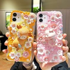 two people holding up cell phones with flowers and animals on them