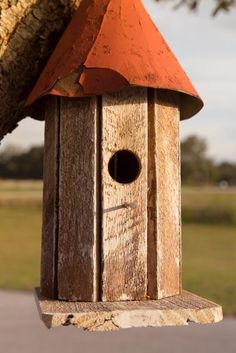 a wooden bird house hanging from a tree