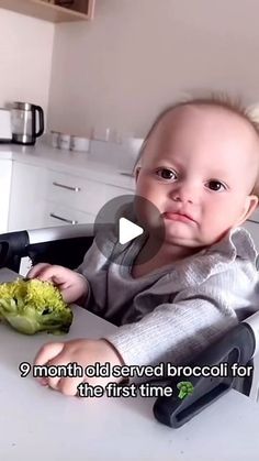 a baby sitting in a high chair eating broccoli