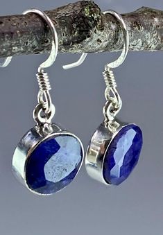 A beautifully eye-catching and sophisticated deep blue faceted raw Sapphire and sterling silver dangle earrings. The feature stone is set in classic half-bezel. Weight - 4 grams (2 grams each) The earrings measure - 1.0 cm in diameter and 0.4 cm deep.  The total drop 2.7 cm. Product made hypoallergenic with pure 925 silver and nickel free. About the stone: Most of the 'big three' gemstones - emeralds, rubies and sapphires - are in some way enhanced or treated. Only the very pure, perfectly colou Silver Faceted Oval Earrings, Silver Oval Faceted Earrings, Sterling Silver Sapphire Gemstone Earrings, Faceted Round Sapphire Jewelry, Sterling Silver Dangle Earrings With Bezel Setting, Sterling Silver Jewelry With Bezel Setting And Dangle Shape, Sterling Silver Faceted Earrings For Anniversary, Sterling Silver Earrings With Bezel Setting As Gift, Silver Sapphire Dangle Jewelry