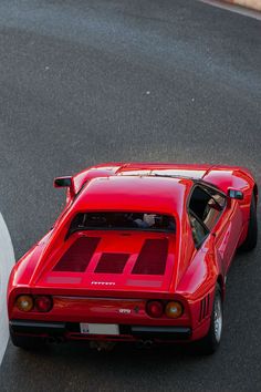 a red sports car driving down a race track