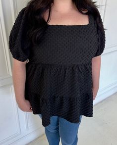 This black ruffled blouse is a plus size must-have. The puff sleeves add a touch of drama, while the textured woven fabric elevates its look. The square neck gives a flattering neckline to any outfit. Perfect for any occasion, this blouse is versatile and stylish. Chic Black Puff Sleeve Top With Ruffles, Black Ruffle Square Neck Top, Chic Black Blouse With Square Neck, Chic Black Square Neck Blouse, Spring Black Square Neck Blouse, Black Square Neck Blouse For Spring, Black Square Neck Puff Sleeve Top For Spring, Black Ruffle Blouse, Ruffled Blouse