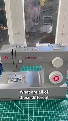 a sewing machine sitting on top of a table next to a window with the words, what are all of these different types of sewing machines?