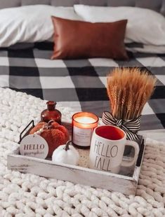 a tray with candles, coffee mugs and marshmallows sits on a bed