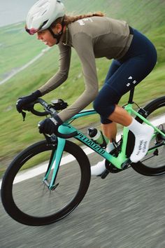 a woman is riding her bike down the road