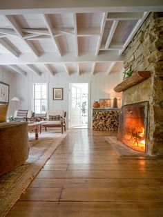 a living room with a fire place in the center and wood floors on both sides