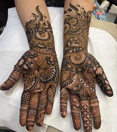 two hands with henna designs on them