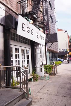 an egg shop on the side of a building with stairs leading up to it's entrance