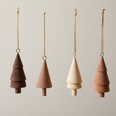 four wooden ornaments hanging from strings in different shapes and sizes, including one for the tree