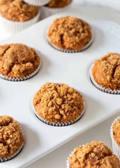 muffins are sitting on a white tray and ready to be baked in the oven