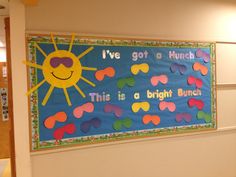 a bulletin board is hanging on the wall in an office building with children's artwork