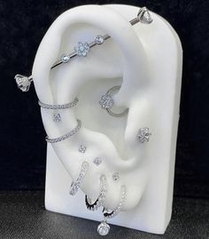 an earring and ring display in a white case with diamonds on the inside of it