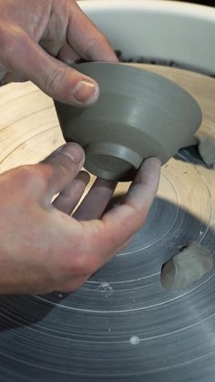 a person working on a piece of wood with a circular sawtoothing wheel in the foreground