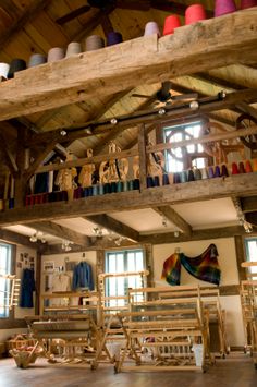 the inside of a building with lots of different colored hats hanging from the ceiling and windows