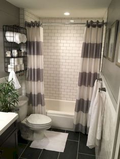 a white toilet sitting next to a bath tub in a bathroom under a shower curtain