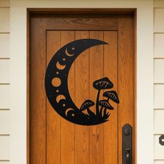 a wooden door with a metal moon and mushrooms on it