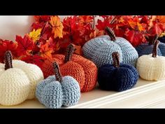 crocheted pumpkins are lined up on a mantle