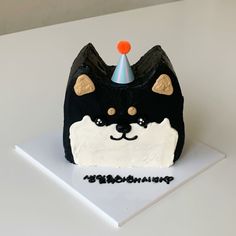 a black and white cat cake with a party hat on top