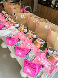 there are many bags on the table that have been decorated with pink and white letters