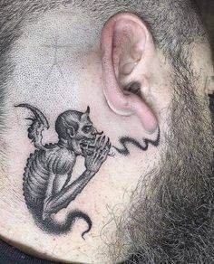 a man with a skull and devil tattoo on his neck is shown behind the ear