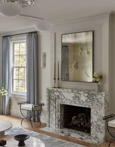 a living room with a fireplace and chairs