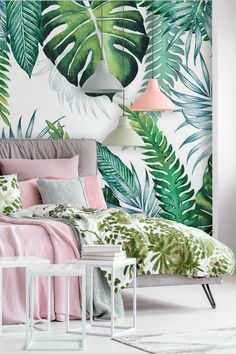 a bedroom decorated in pink, green and white with palm leaves on the wall behind the bed