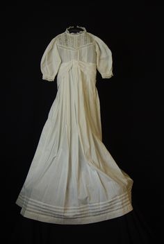 A lovely white cotton antique Christening gown dated from mid to late 1800's Victorian era. Dress is light weight cotton with tuck pleats on bodice & around hemline. It is unlined and has lace on bodice & edge of sleeves. The waist is shirred & can be adjusted  and there is a wide sash attached at front that ties at the back. The opening at the back has 5 very tiny ( 1/4" ) white buttons. It measures 19"  around chest, 7 1/2" sleeve and 35" length.  The dress is in excellent condition for age & Regency Prairie Dress With Empire Waist For Wedding, Regency Style Prairie Dress With Empire Waist For Weddings, Regency Style Empire Waist Prairie Wedding Dress, White Cotton Prairie Dress For Wedding, White Cotton Victorian Dress For Wedding, White Victorian Cotton Dress, White Cotton Victorian Wedding Dress, Cotton Empire Waist Wedding Dress, White Cotton Vintage Wedding Dress