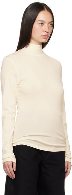 Rib knit cotton turtleneck. Overlock stitching throughout. Supplier color: Light cream White Fine Knit Turtleneck Top, Classic Turtleneck Top In Winter White, Classic Winter White Turtleneck Top, White Fine Knit Turtleneck With Funnel Neck, Elegant Winter White Turtleneck Top, Cream Long Sleeve Turtleneck, Winter White Turtleneck Top For Layering, Cream Turtleneck Spring Tops, Cream Turtleneck Tops For Spring