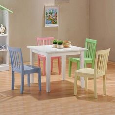 a white table and four chairs in a room with hardwood floors, painted pink, green, yellow and blue