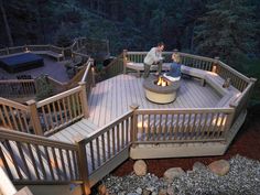 an aerial view of a deck and hot tub in a backyard at night with lights on