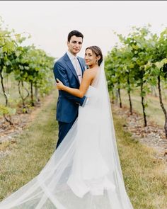 a bride and groom posing for a photo in the vineyard