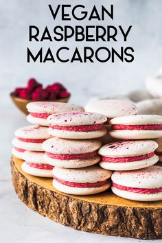 a stack of raspberry macaroons sitting on top of a wooden cutting board