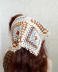 a woman with long hair wearing a crocheted hat on top of her head