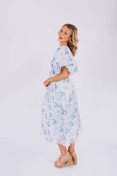 Indulge in the dreamy charm of our EXCLUSIVE Lost In A Dream Dress. Featuring a beautiful blue floral print, smocked bust, and delicate ruffle details. This midi dress is an exclusive design found only at One Loved Babe. With inclusive sizing from XS to 6XL, this dress is perfect for everyone! Details Textured fabric along bust Exaggerated puff sleeve Corset inspired Lined Invisible zipper back closure Shirred back Piping details Blue floral Sizing *Measurements are taken with item hanging.* App Light Blue Floral Print Midi Dress For Brunch, Breezy Floral Print Midi Dress For Daywear, Feminine Blue Floral Dress For Garden Party, Flowy Light Blue Midi Dress For Daywear, Blue Breezy Midi Dress For Garden Party, Breezy Blue Midi Dress For Garden Party, Blue Chiffon Floral Dress For Spring, Blue Chiffon Dress For Daywear, Feminine Blue Chiffon Midi Dress