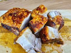 several pieces of meat sitting on top of a cutting board